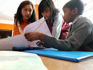 Teacher in India checking students' homework